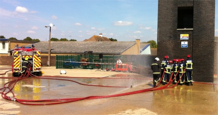 Firemen, handling their hoses correctly